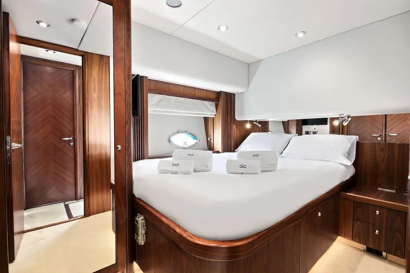 Infinito Yacht Photos Pics Luxurious bedroom interior of 2007 Sunseeker Predator 82 yacht with elegant wood finishes.