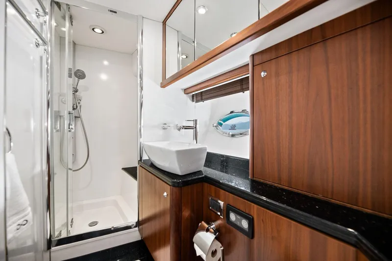 Infinito Yacht Photos Pics Luxurious bathroom in 2007 Sunseeker Predator 82 yacht with modern fixtures and wood accents.