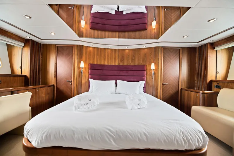 Infinito Yacht Photos Pics Luxurious bedroom interior of 2007 Sunseeker Predator 82 yacht with elegant wood paneling.