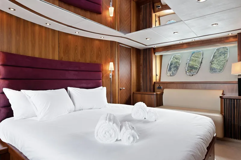Infinito Yacht Photos Pics Luxurious bedroom interior on 2007 Sunseeker Predator 82 yacht, featuring elegant wood paneling.