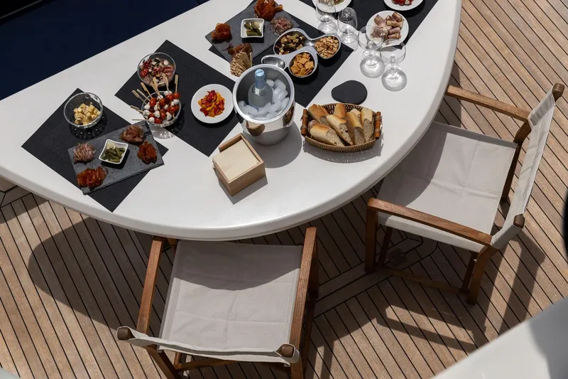 Infinito Yacht Photos Pics Luxurious dining setup on 2007 Sunseeker Predator 82 yacht deck with gourmet appetizers.