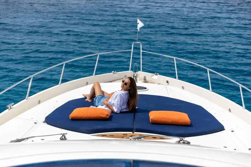 Infinito Yacht Photos Pics Woman relaxing on 2007 Sunseeker Predator 82 yacht, enjoying sunny day at sea.