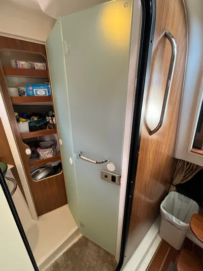  Yacht Photos Pics Interior of 2010 Pursuit OS 345 Offshore boat with frosted glass door and storage shelves.