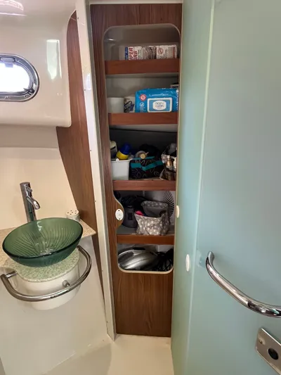  Yacht Photos Pics 2010 Pursuit OS 345 Offshore bathroom with glass sink and storage shelves.