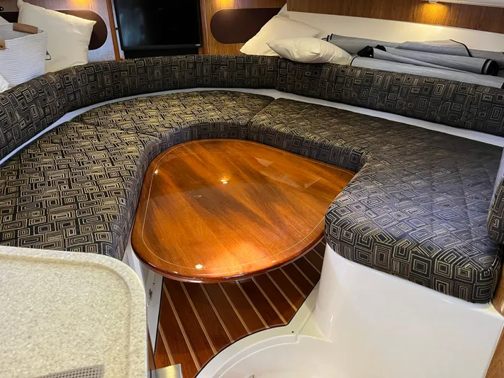  Yacht Photos Pics 2010 Pursuit OS 345 Offshore cabin with patterned seating and wooden table.