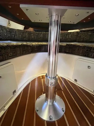  Yacht Photos Pics 2010 Pursuit OS 345 Offshore cabin interior with polished metal table support and cushioned seating.