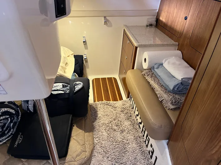  Yacht Photos Pics 2010 Pursuit OS 345 Offshore cabin interior with cozy seating and storage.