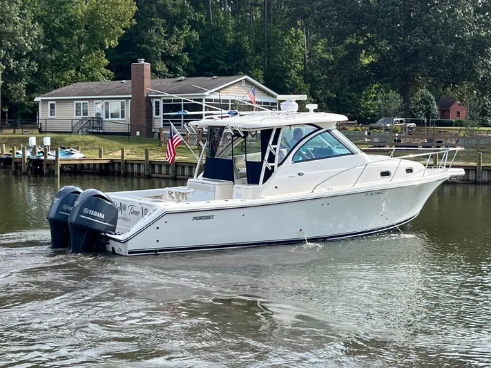  Yacht Photos Pics 2010 Pursuit OS 345 Offshore boat cruising near a lakeside house with Yamaha engines.
