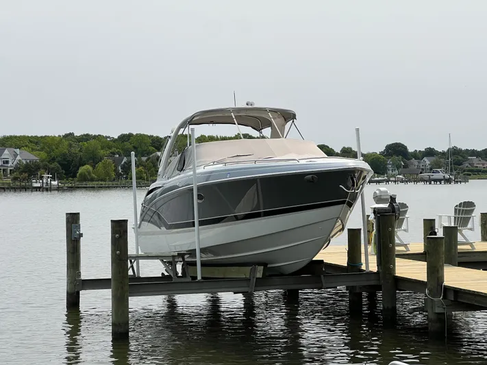 4th Quarter Yacht Photos Pics 2016 Formula 310 Bowrider boat docked on a lift by a serene waterfront.