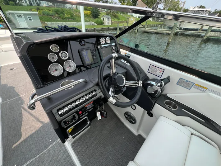 4th Quarter Yacht Photos Pics 2016 Formula 310 Bowrider helm with gauges, steering wheel, and controls by the water.