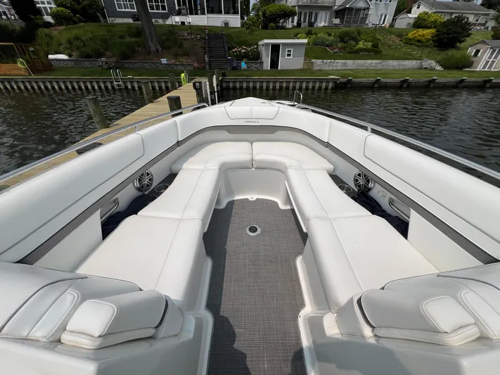 4th Quarter Yacht Photos Pics 2016 Formula 310 Bowrider with spacious white seating, docked by a waterfront.