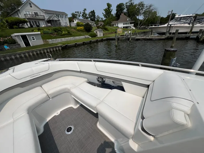 4th Quarter Yacht Photos Pics 2016 Formula 310 Bowrider with white seating, docked near waterfront homes.