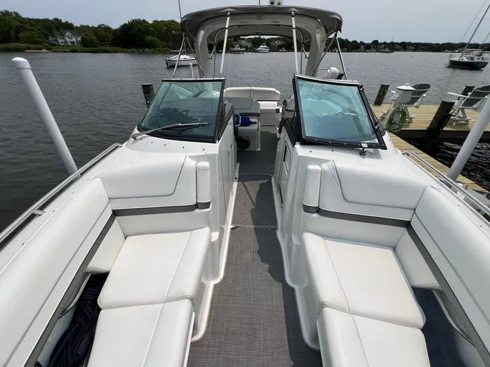 4th Quarter Yacht Photos Pics 2016 Formula 310 Bowrider with spacious seating, docked by a serene waterfront.