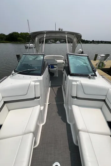 4th Quarter Yacht Photos Pics 2016 Formula 310 Bowrider boat with spacious seating, docked by a serene lake.