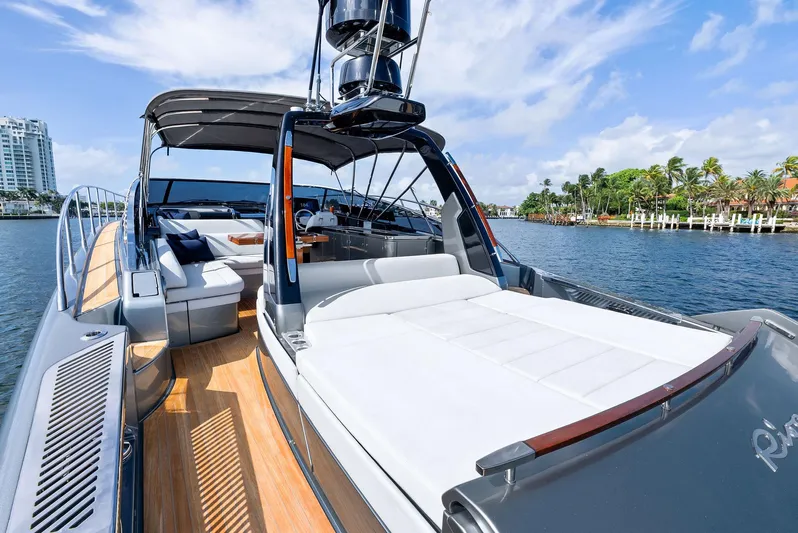 Phantom Yacht Photos Pics 2019 Riva 56 Rivale luxury yacht with spacious deck and elegant seating, docked by waterfront.