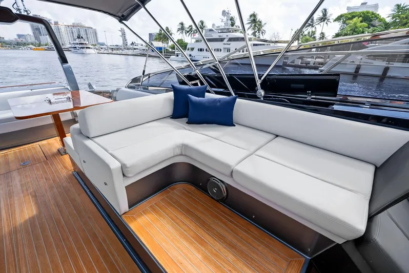 Phantom Yacht Photos Pics Luxurious 2019 Riva 56 Rivale yacht interior with white seating and wooden deck.