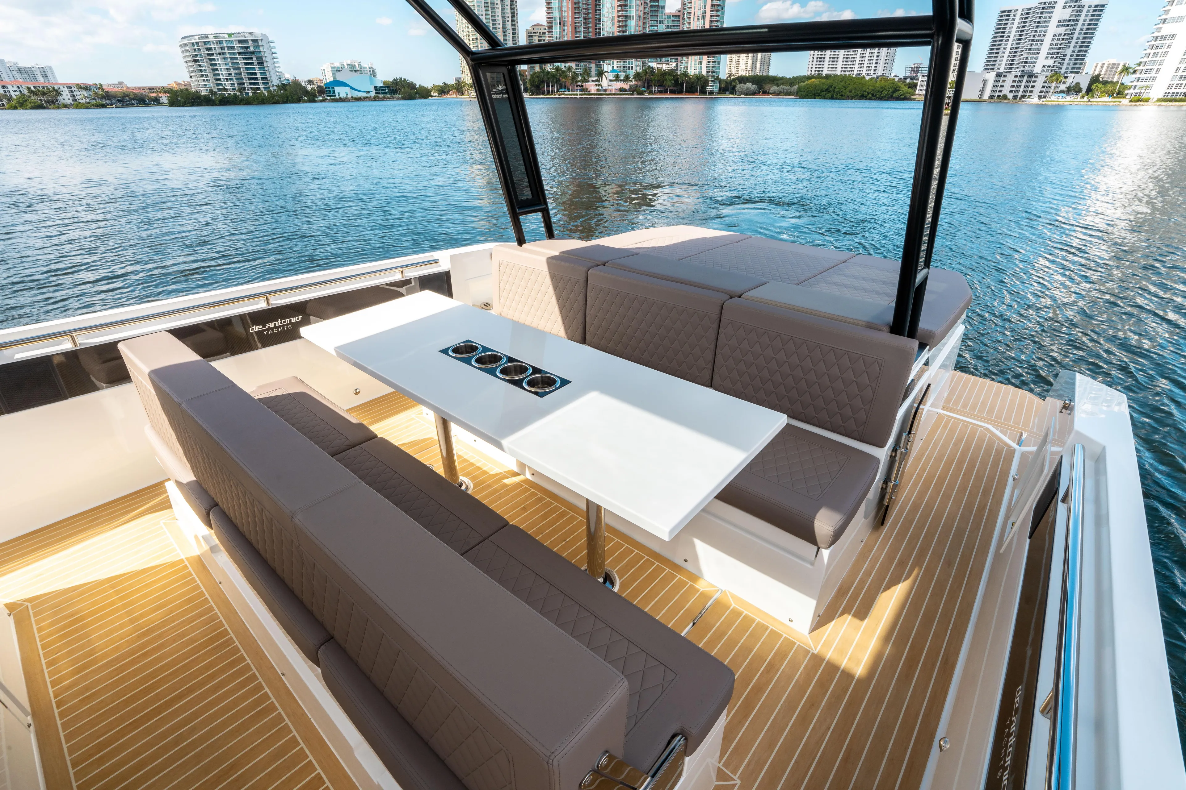  Yacht Photos Pics 2025 De Antonio Yachts D32 OPEN interior with seating and table on a sunny day.