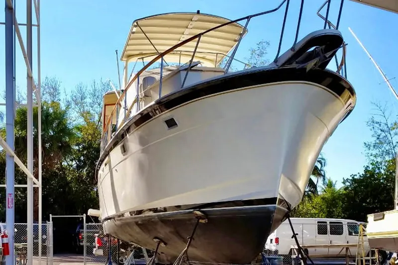 Rubber Ducky Yacht Photos Pics 1981 Hatteras 48 Motor Yacht on dry dock, side view with trees in background.