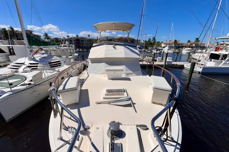 Rubber Ducky Yacht Photos Pics 1981 Hatteras 48 Motor Yacht docked in a sunny marina, surrounded by other boats.