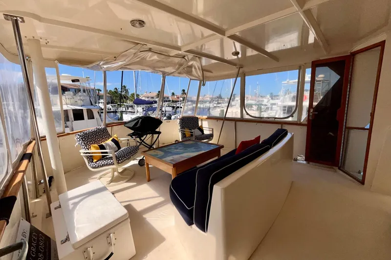 Rubber Ducky Yacht Photos Pics 1981 Hatteras 48 Motor Yacht interior with seating, table, and marina view.
