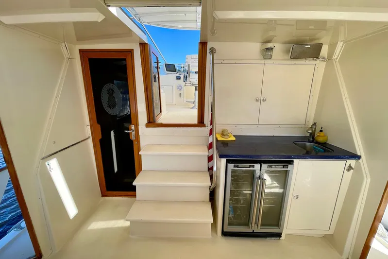 Rubber Ducky Yacht Photos Pics 1981 Hatteras 48 Motor Yacht interior with kitchenette, stairs, and storage cabinets.