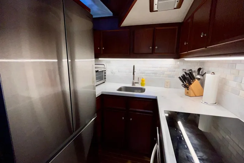 Rubber Ducky Yacht Photos Pics Modern kitchen in 1981 Hatteras 48 Motor Yacht with stainless steel appliances and dark wood cabinets.