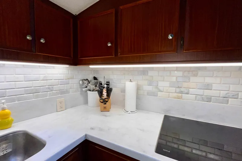 Rubber Ducky Yacht Photos Pics 1981 Hatteras 48 Motor Yacht kitchen with marble countertop and wooden cabinets.