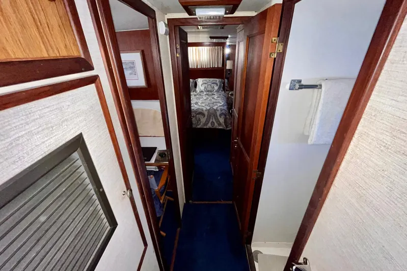Rubber Ducky Yacht Photos Pics 1981 Hatteras 48 Motor Yacht interior hallway with wood paneling and bedroom view.