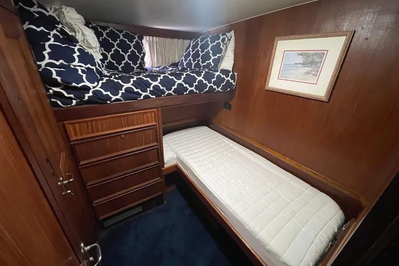 Rubber Ducky Yacht Photos Pics 1981 Hatteras 48 Motor Yacht cabin with bunk beds, wood paneling, and nautical decor.