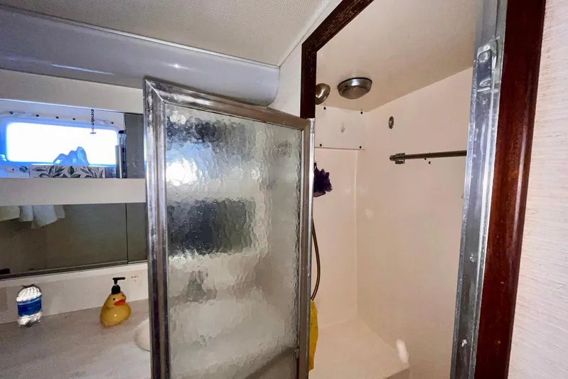 Rubber Ducky Yacht Photos Pics 1981 Hatteras 48 Motor Yacht bathroom with shower, mirror, and countertop accessories.