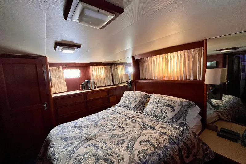 Rubber Ducky Yacht Photos Pics Cozy bedroom in 1981 Hatteras 48 Motor Yacht with elegant wood paneling and patterned bedding.