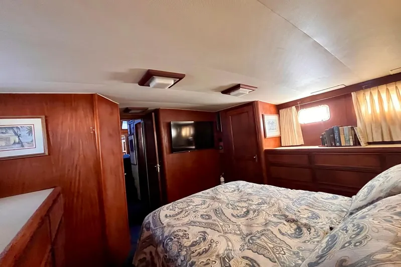 Rubber Ducky Yacht Photos Pics 1981 Hatteras 48 Motor Yacht interior cabin with wood paneling and cozy bedding.
