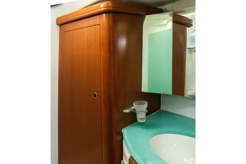  Yacht Photos Pics Interior of 2007 Beneteau Oceanis 523 yacht bathroom with wooden cabinet and turquoise countertop.
