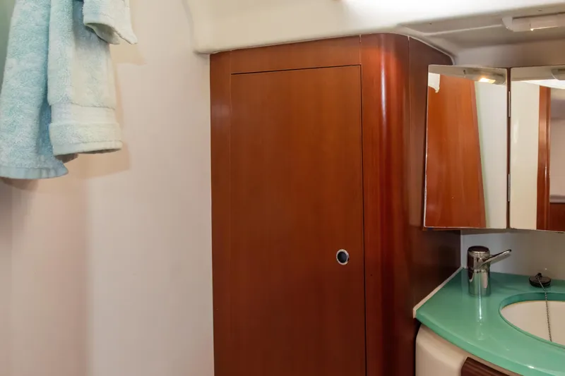  Yacht Photos Pics Beneteau Oceanis 523 bathroom with wooden cabinet, mirror, and towel, 2007 model.