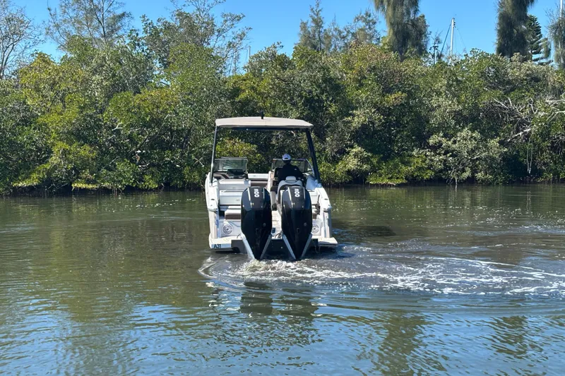  Yacht Photos Pics 2022 Cobalt R8 Outboard boat navigating a calm waterway surrounded by lush greenery.
