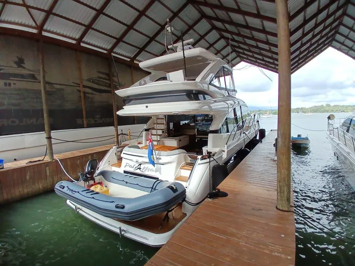 Palmar Yacht Photos Pics Luxury 2023 Princess F55 yacht docked under a covered marina.