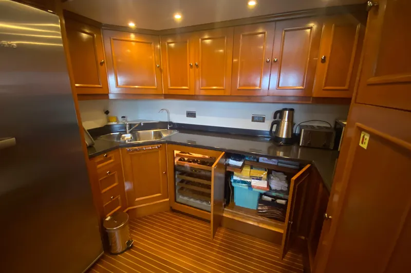 Bdt Yacht Photos Pics Galley kitchen in 2003 Benetti Classic 115 yacht with wooden cabinets and modern appliances.