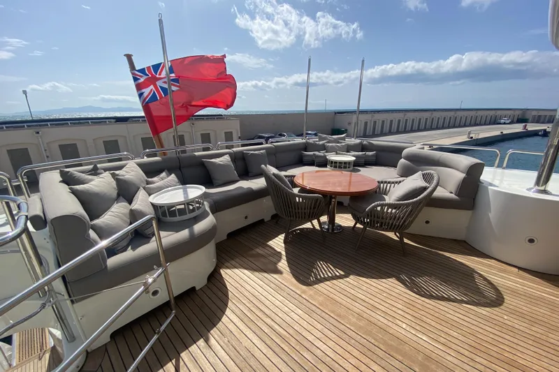 Bdt Yacht Photos Pics Luxurious deck of 2003 Benetti Classic 115 yacht with seating and flag.