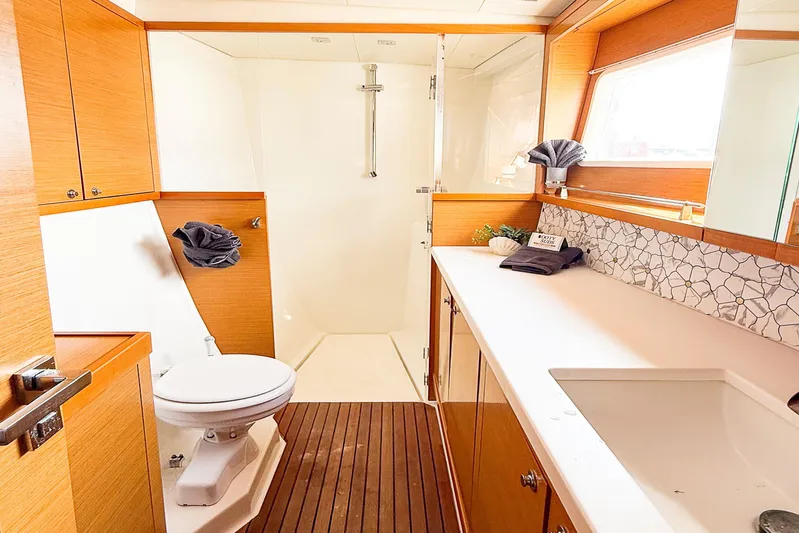  Yacht Photos Pics Luxurious bathroom in 2012 Lagoon 450F yacht with modern fixtures and wooden accents.