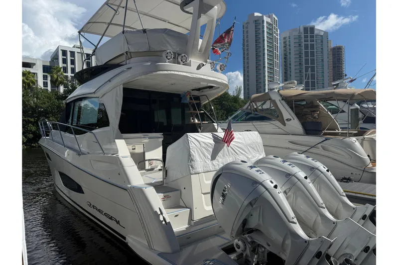  Yacht Photos Pics 2023 Regal 38 FXO yacht docked, featuring triple outboard engines and modern design.