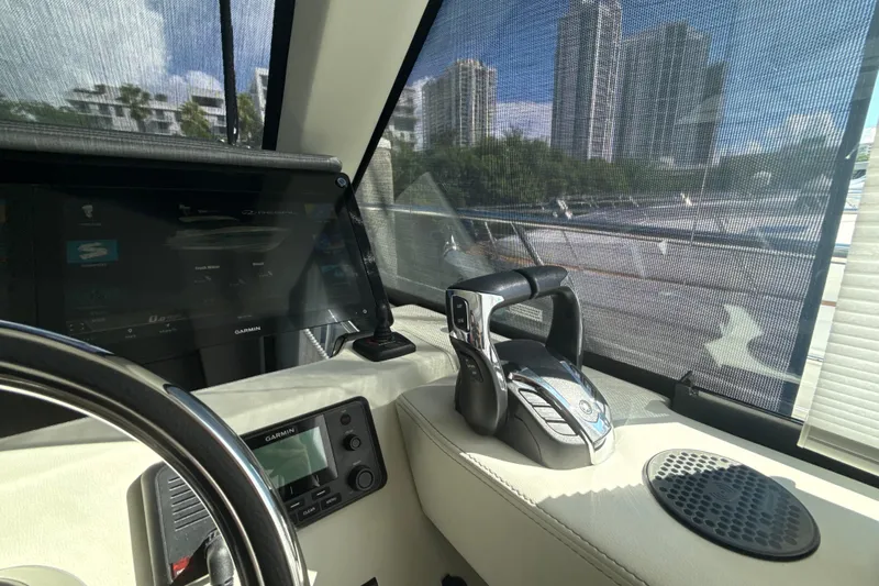  Yacht Photos Pics 2023 Regal 38 FXO yacht cockpit with Garmin navigation and cityscape view.