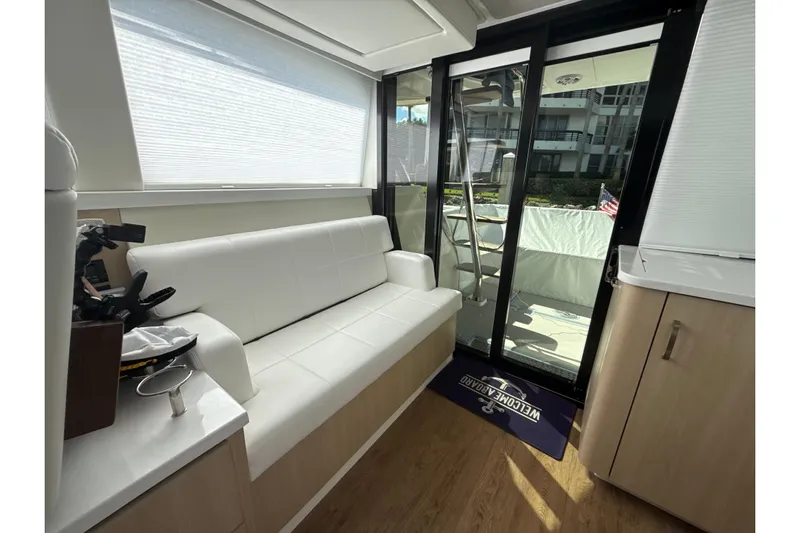  Yacht Photos Pics Luxurious interior of 2023 Regal 38 FXO yacht with white seating and glass doors.