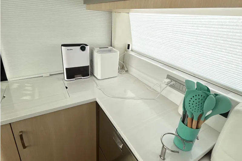  Yacht Photos Pics Modern kitchen area in 2023 Regal 38 FXO yacht with appliances and utensils.