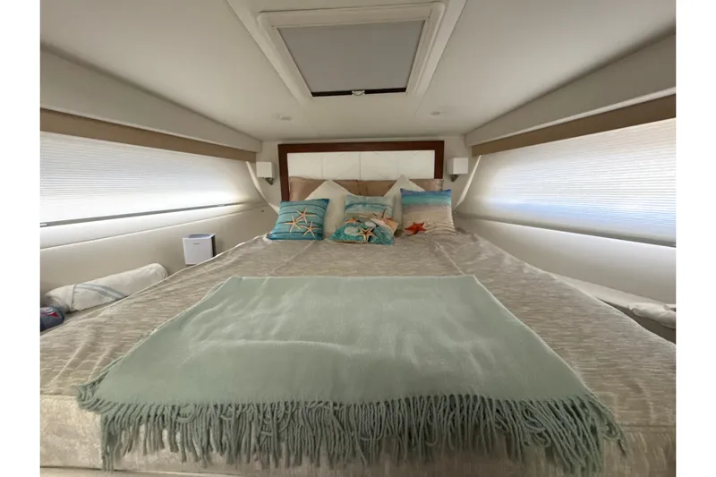  Yacht Photos Pics Luxurious bedroom interior of 2023 Regal 38 FXO yacht with cozy bedding and decorative pillows.