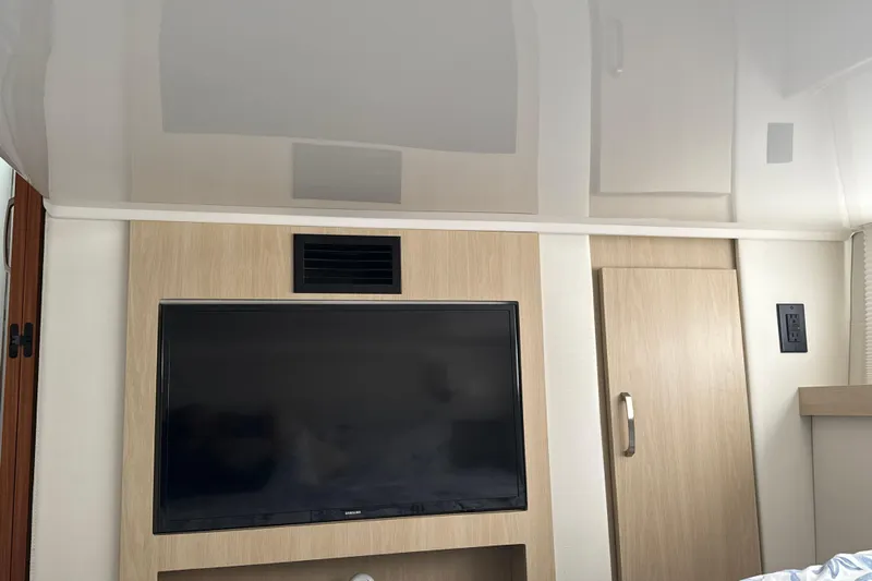  Yacht Photos Pics Interior of 2023 Regal 38 FXO yacht featuring a mounted TV and wooden cabinetry.