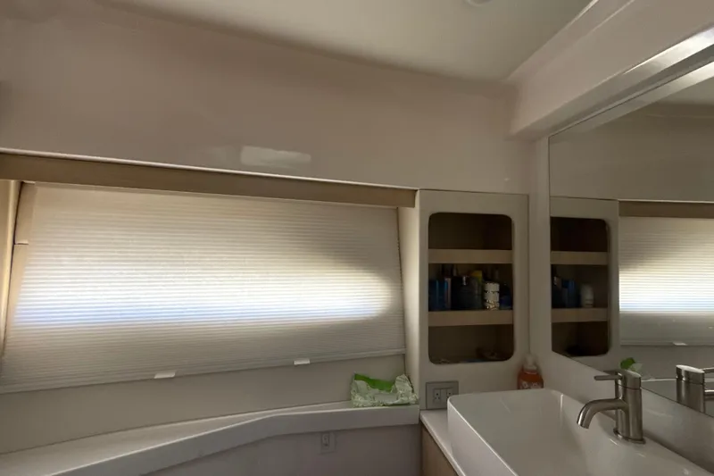  Yacht Photos Pics Luxurious bathroom interior of 2023 Regal 38 FXO yacht with modern sink and storage.