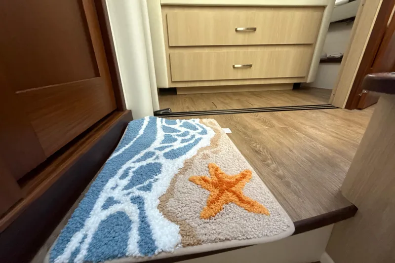  Yacht Photos Pics Interior of 2023 Regal 38 FXO with starfish-themed rug and wooden cabinetry.