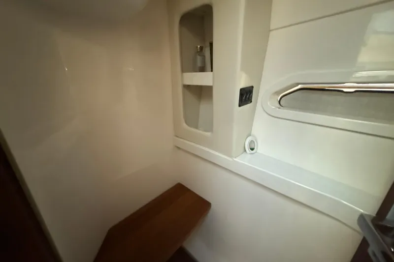  Yacht Photos Pics 2023 Regal 38 FXO interior cabin with wooden seat and storage shelf.