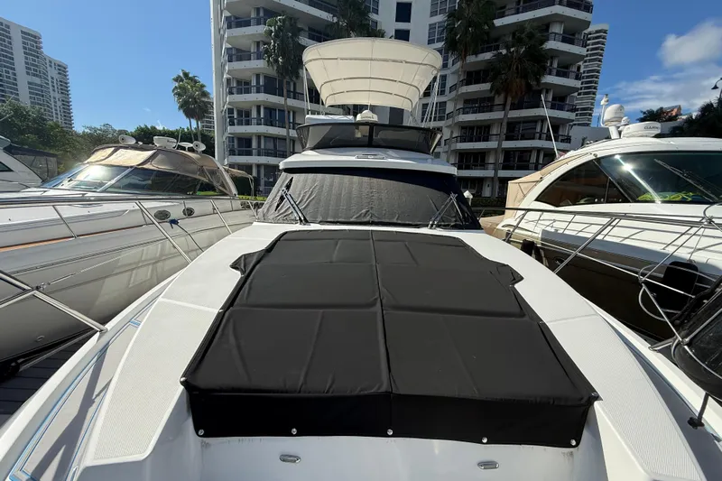  Yacht Photos Pics 2023 Regal 38 FXO yacht docked between buildings, featuring sleek design and sunshade.