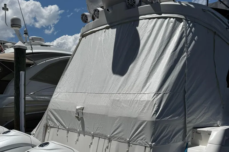  Yacht Photos Pics 2023 Regal 38 FXO yacht with protective cover at marina, under blue sky.